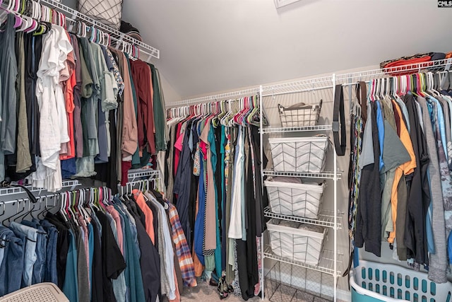 walk in closet featuring carpet floors and vaulted ceiling