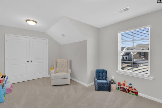 living area with vaulted ceiling and light colored carpet