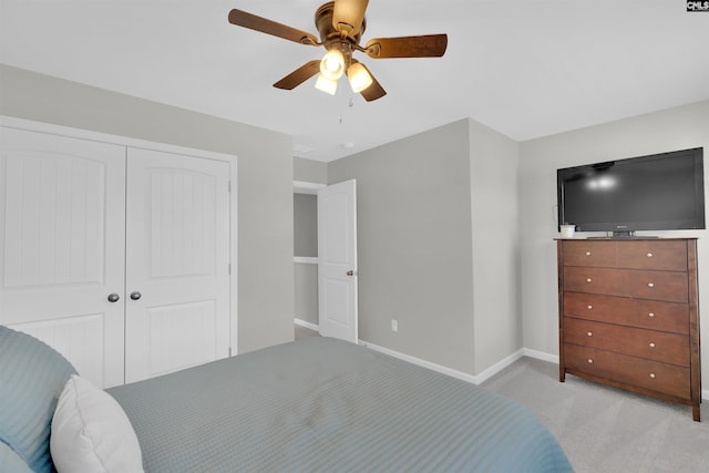 carpeted bedroom featuring ceiling fan and a closet