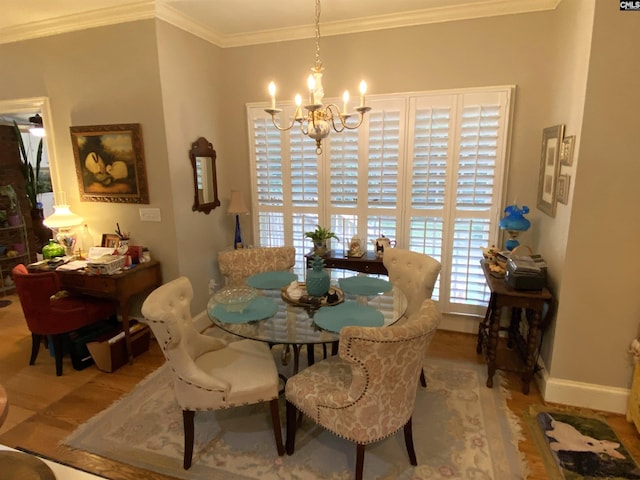 dining space with crown molding, hardwood / wood-style floors, and an inviting chandelier