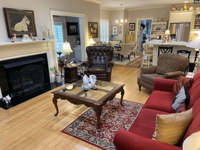 living room with an inviting chandelier, crown molding, and light hardwood / wood-style floors