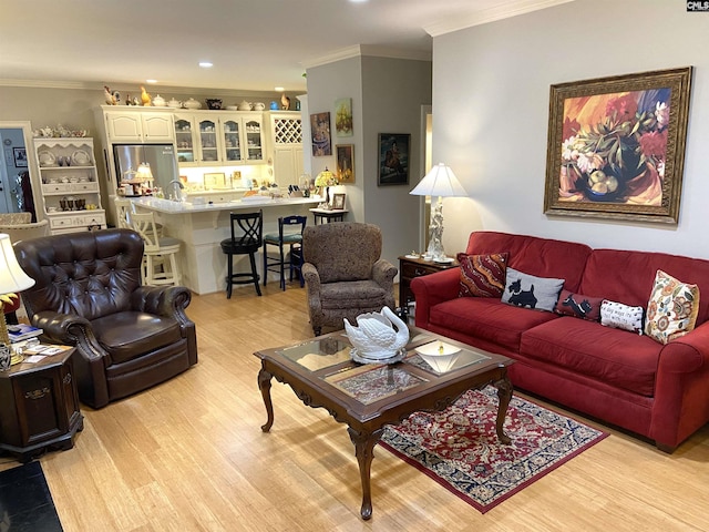 living room featuring ornamental molding and light hardwood / wood-style flooring