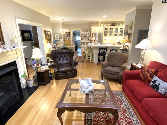 living room featuring crown molding, light hardwood / wood-style floors, and a chandelier