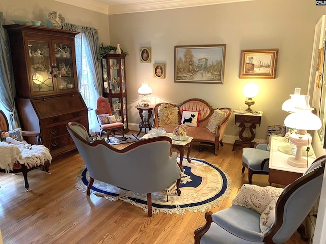 living area with crown molding and light wood-type flooring