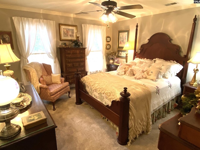 carpeted bedroom with ornamental molding and ceiling fan