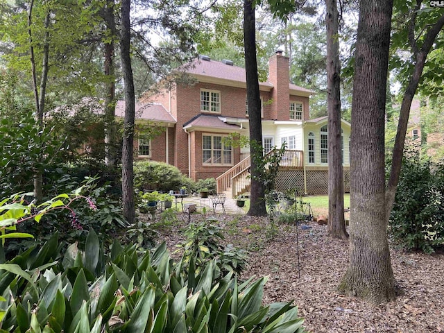 rear view of house featuring a wooden deck