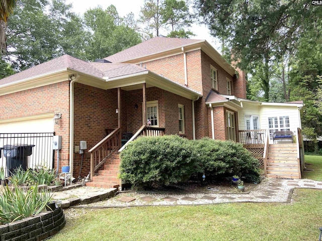 back of property featuring a garage and a lawn