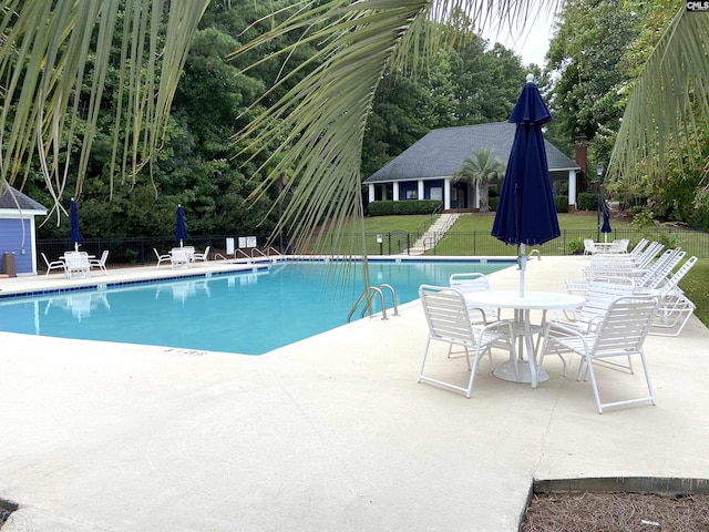 view of swimming pool featuring a yard and a patio