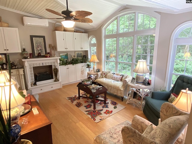 living room with lofted ceiling, ceiling fan, a wall mounted air conditioner, a fireplace, and light hardwood / wood-style floors