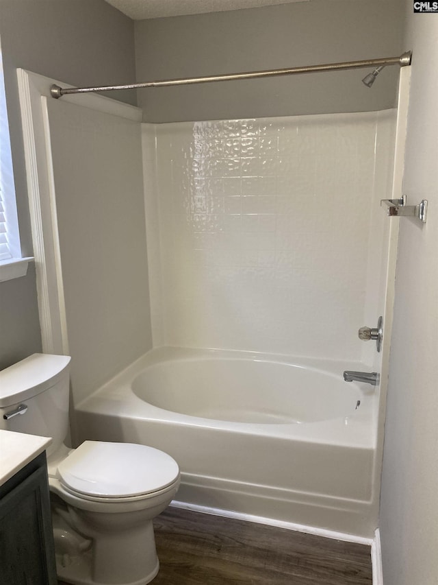 full bathroom featuring vanity, hardwood / wood-style floors, shower / washtub combination, and toilet