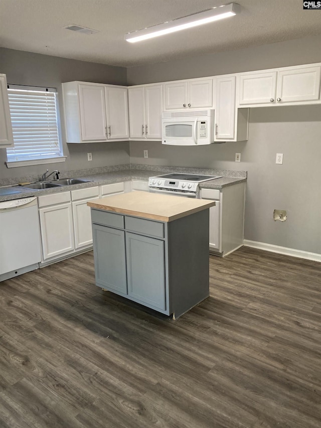 kitchen featuring white cabinetry, white appliances, a center island, and sink