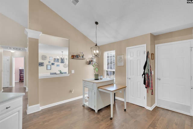 dining area featuring lofted ceiling, a notable chandelier, and dark hardwood / wood-style flooring