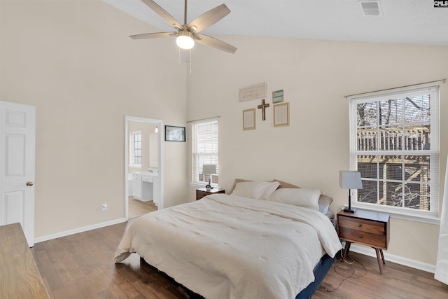 bedroom with hardwood / wood-style floors, high vaulted ceiling, and ensuite bathroom