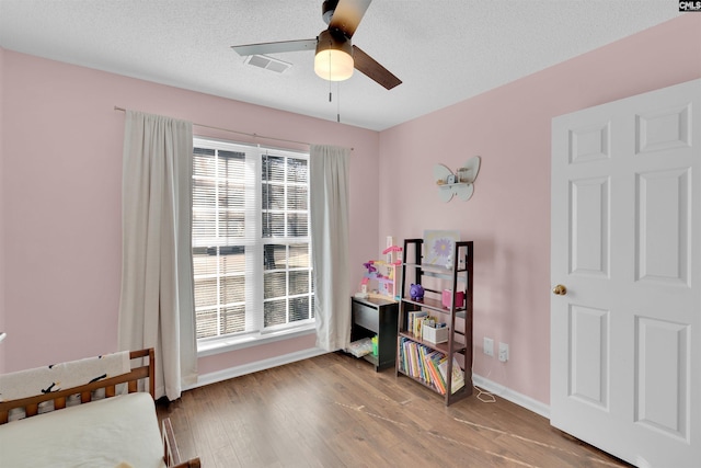 interior space with hardwood / wood-style flooring, ceiling fan, plenty of natural light, and a textured ceiling