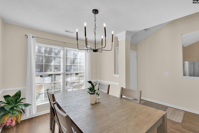 dining area with wood-type flooring, a textured ceiling, and a wealth of natural light