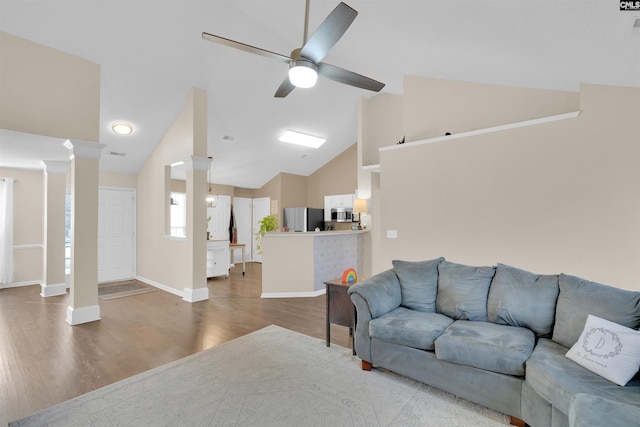 living room featuring decorative columns, high vaulted ceiling, hardwood / wood-style flooring, and ceiling fan