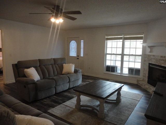 living room featuring ceiling fan, dark wood-type flooring, and a fireplace