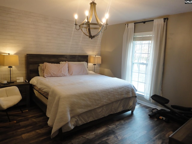 bedroom with dark wood-type flooring and an inviting chandelier