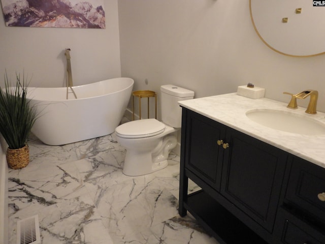 bathroom featuring vanity, toilet, and a washtub