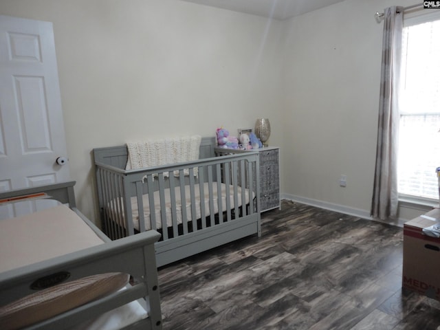 bedroom with multiple windows and dark wood-type flooring