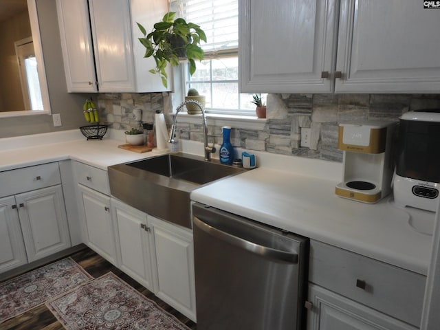 kitchen featuring sink, dark wood-type flooring, white cabinetry, backsplash, and stainless steel dishwasher