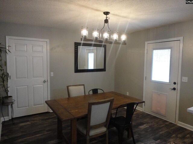 dining space featuring dark hardwood / wood-style flooring, a chandelier, and a textured ceiling