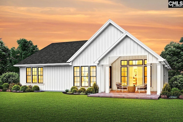 back house at dusk featuring a yard