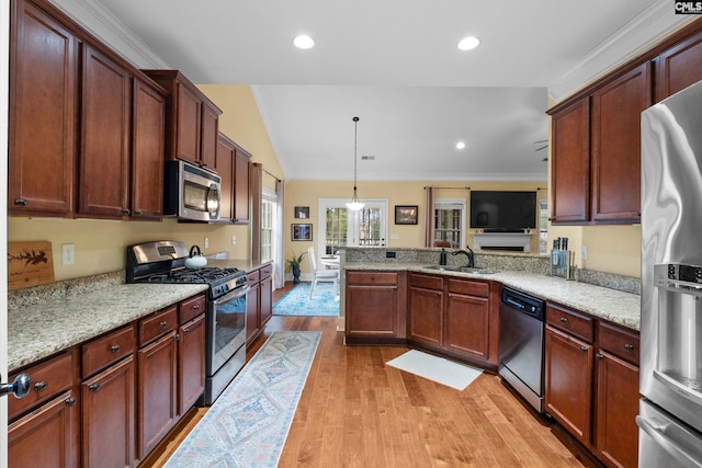 kitchen with pendant lighting, sink, light stone counters, and appliances with stainless steel finishes