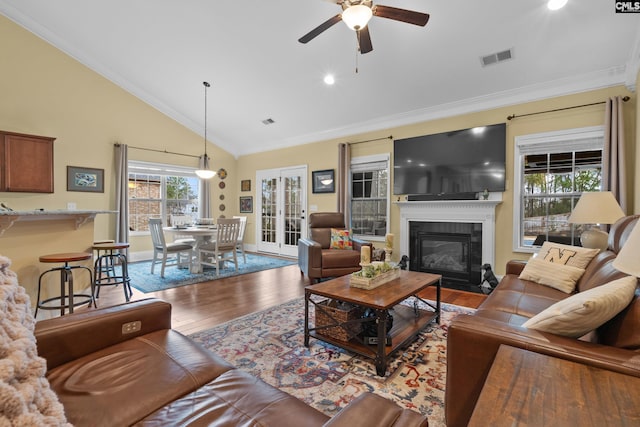 living room with crown molding, wood-type flooring, french doors, and ceiling fan