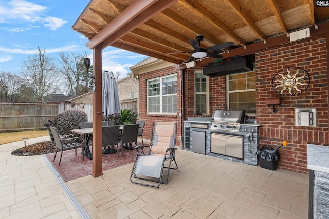 view of patio / terrace with ceiling fan, area for grilling, and exterior kitchen