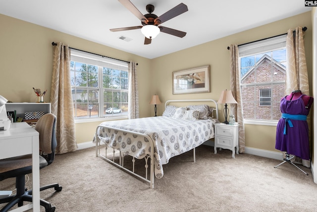 carpeted bedroom with multiple windows and ceiling fan