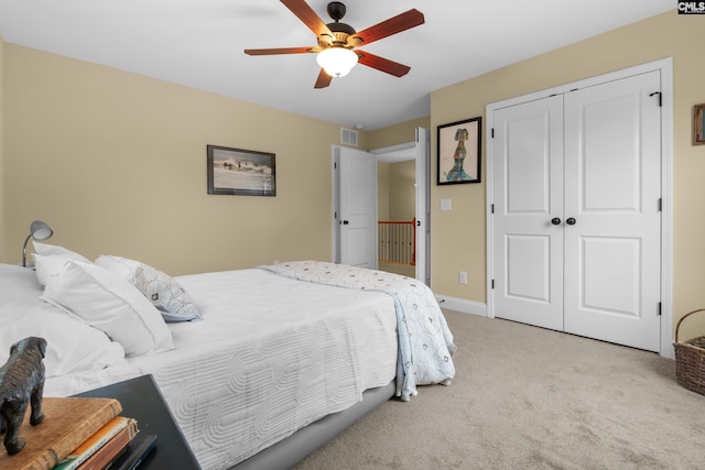 carpeted bedroom featuring ceiling fan and a closet