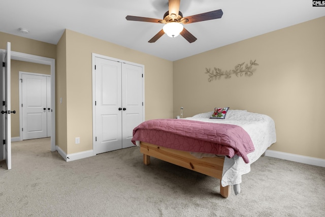 bedroom with ceiling fan, light colored carpet, and a closet