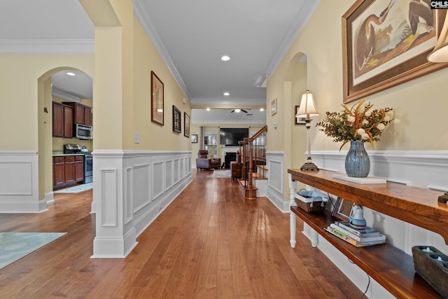 hallway featuring wood-type flooring and ornamental molding