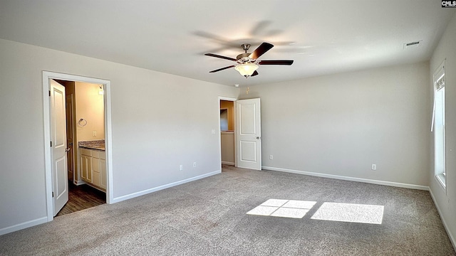 unfurnished bedroom featuring ceiling fan, ensuite bathroom, and carpet floors