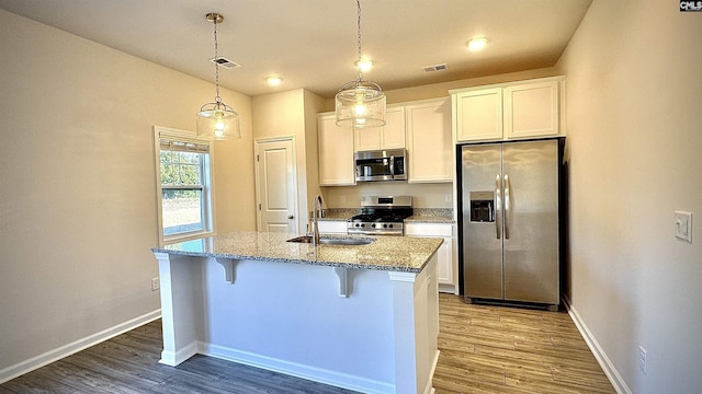 kitchen featuring appliances with stainless steel finishes, a kitchen island with sink, sink, and white cabinets