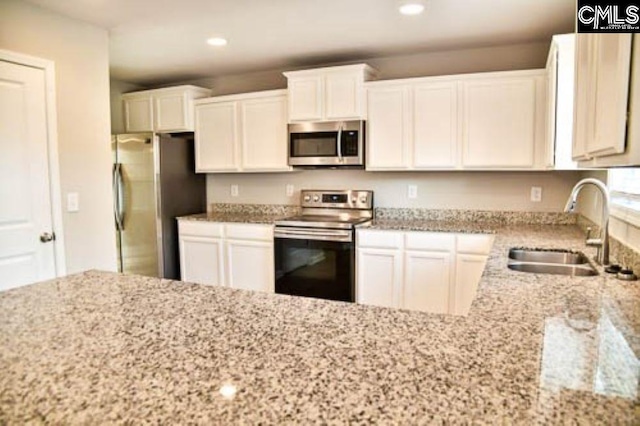 kitchen featuring white cabinetry, sink, light stone counters, and stainless steel appliances