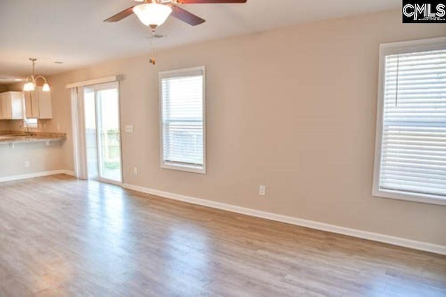 unfurnished living room with ceiling fan and light wood-type flooring