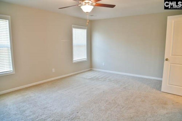 spare room featuring light carpet and ceiling fan