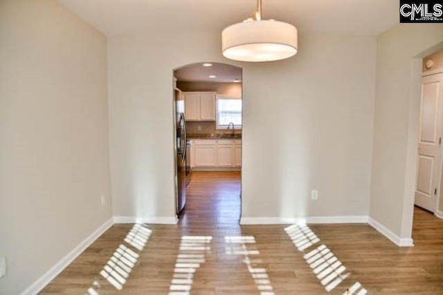 unfurnished dining area with wood-type flooring and sink