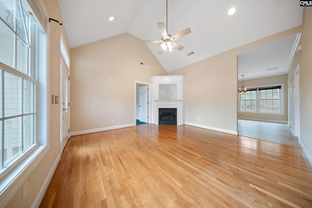 unfurnished living room featuring high vaulted ceiling, ceiling fan, and light hardwood / wood-style flooring