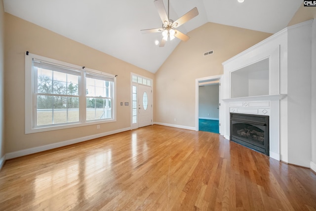 unfurnished living room with high vaulted ceiling, light hardwood / wood-style floors, and ceiling fan