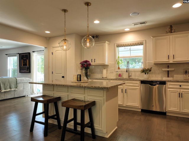 kitchen featuring a center island, dishwasher, sink, and white cabinets