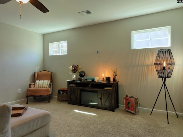 sitting room featuring light carpet and ceiling fan