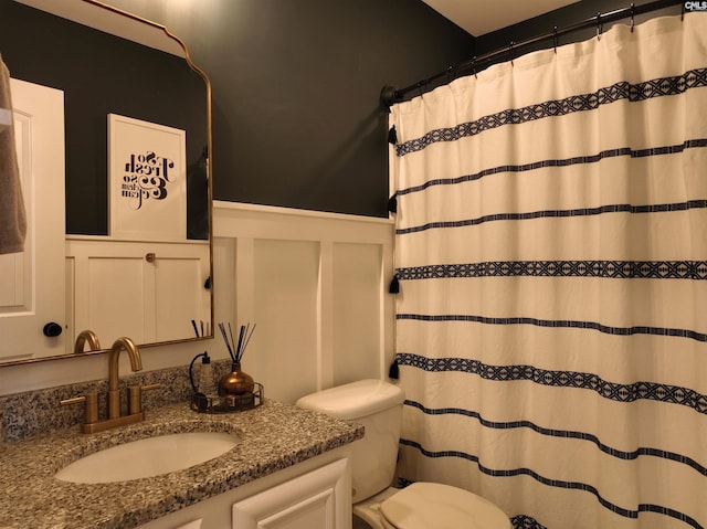 bathroom with vanity, curtained shower, and toilet