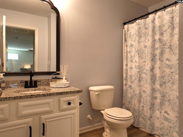 bathroom with a shower with curtain, vanity, hardwood / wood-style floors, and toilet