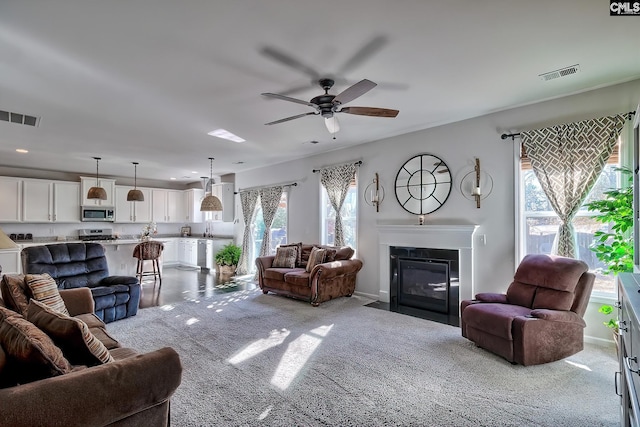 living room featuring light carpet and ceiling fan