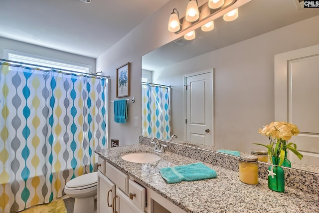 bathroom featuring vanity, toilet, and walk in shower