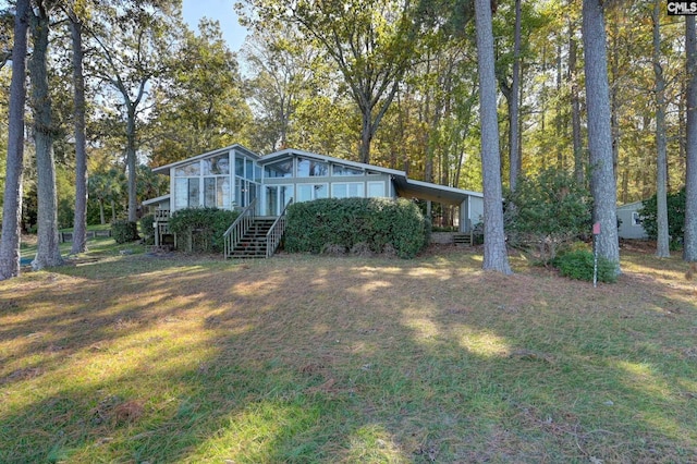 view of front facade featuring a front lawn and a sunroom