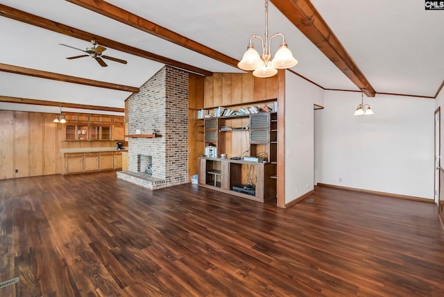 unfurnished living room featuring a brick fireplace, ceiling fan with notable chandelier, dark wood-type flooring, and wood walls